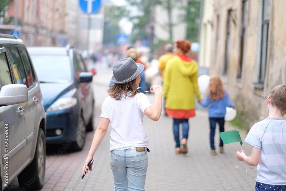 A small group of children is walking along the city street A small group of children is walking along the city street
