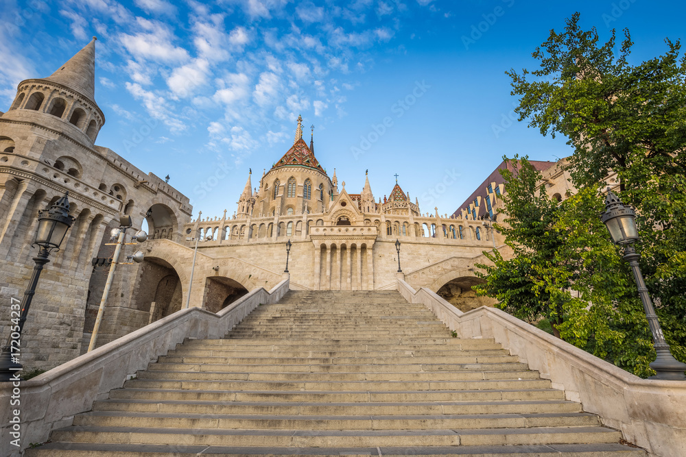 Fototapeta premium Budapest, Hungary - The beautiful stairs of the Fisherman bastion with the Matthias Church in the morning with blue sky