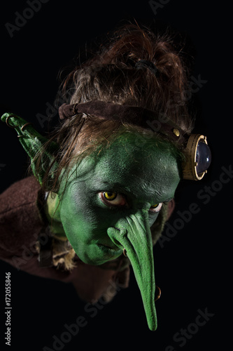 Bild auf Leinwand böser grüner Kobold mit langer Nase vor schwarzem Hintergrund