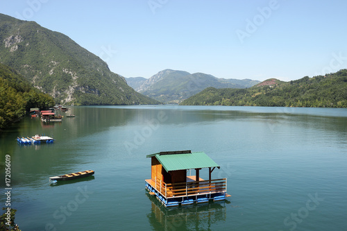 wooden house floating on Drina river landscape