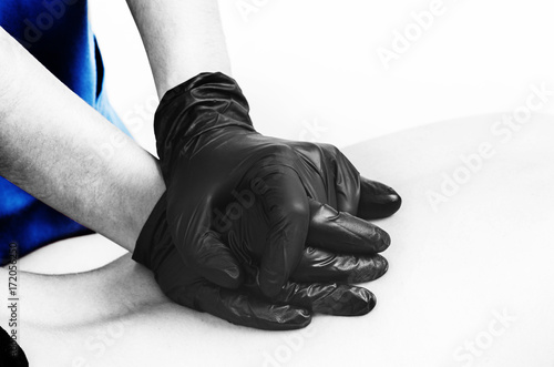 Physiotherapist, chiropractor giving a massage with gloves to a patient in silhouette isolated on white background. Color and black and white