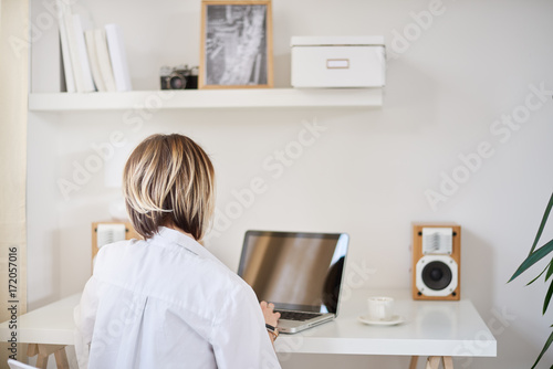 Caucasian freelancer working on laptop at home office