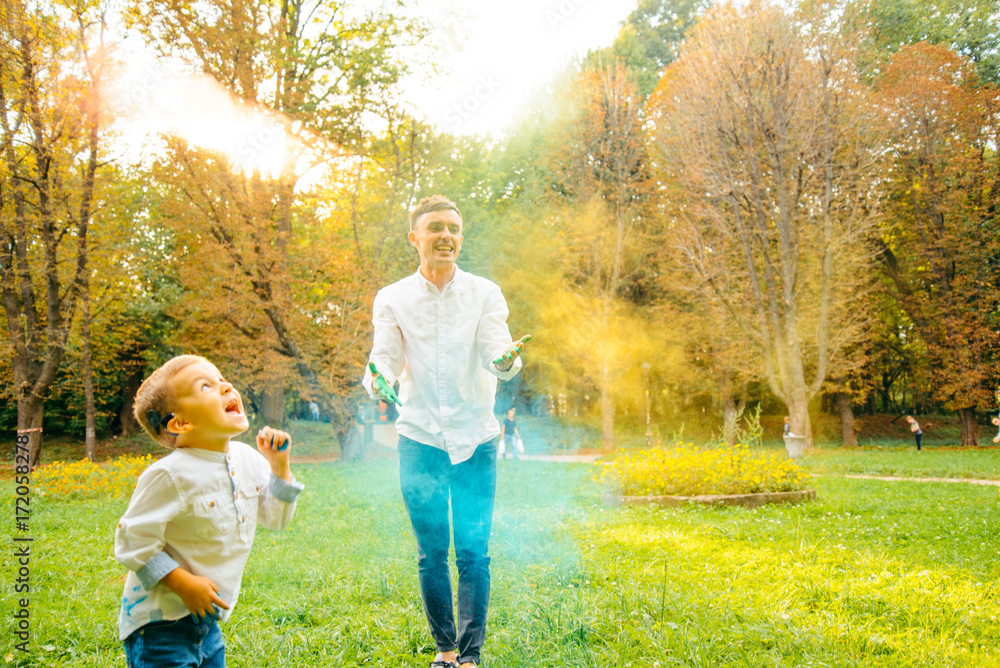 Fototapeta premium Fathers and children in the park palys with holi paints