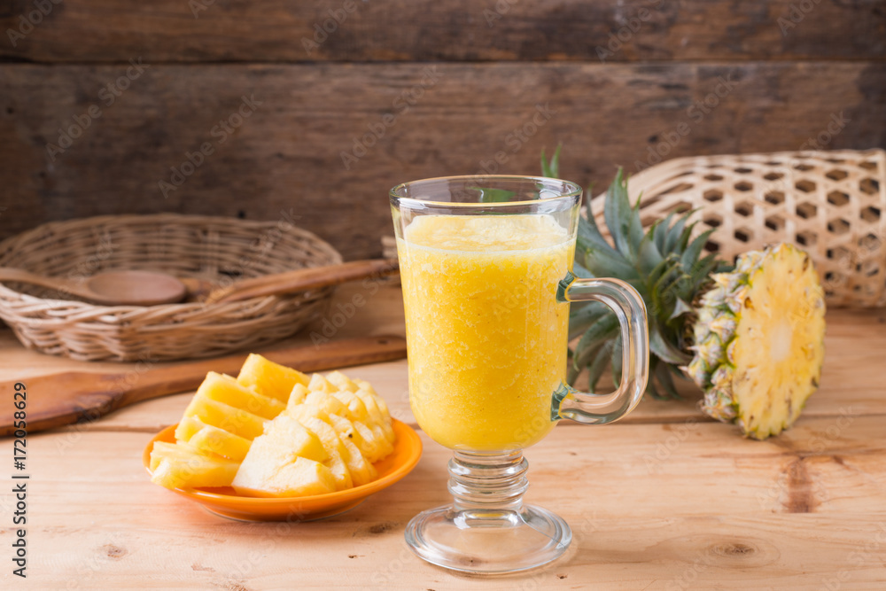 Fototapeta premium Pineapple smoothie on wood background