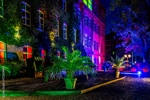 Illuminated terrace of an old building in blue and pink in old district