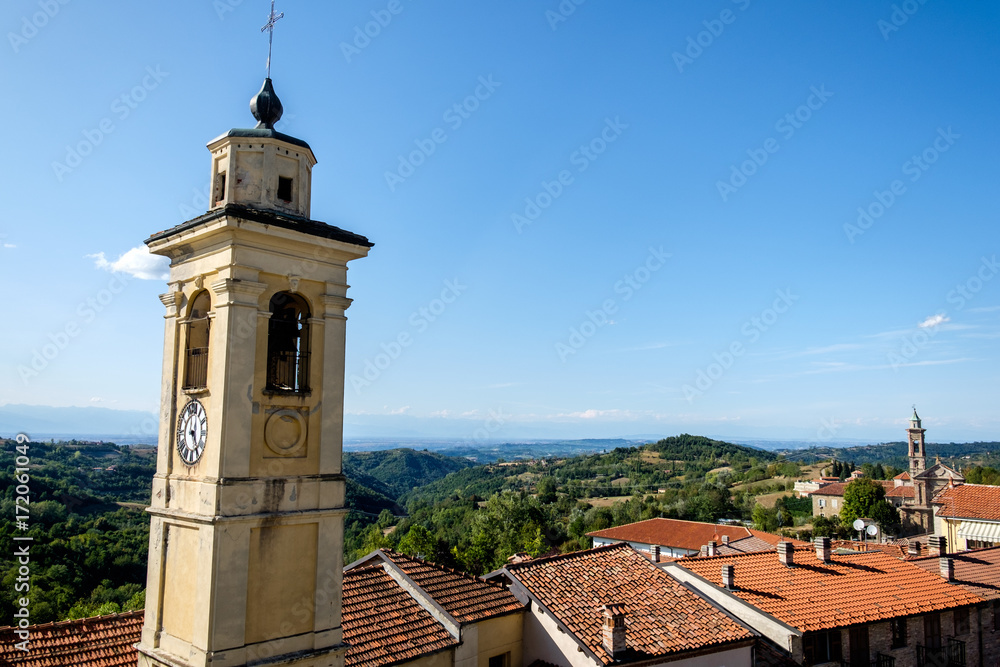 View of the churches of the town of Murazzano, in the langhe region of Piedmont, Italy. In the background, Langhe hills and italian Alps are visible.