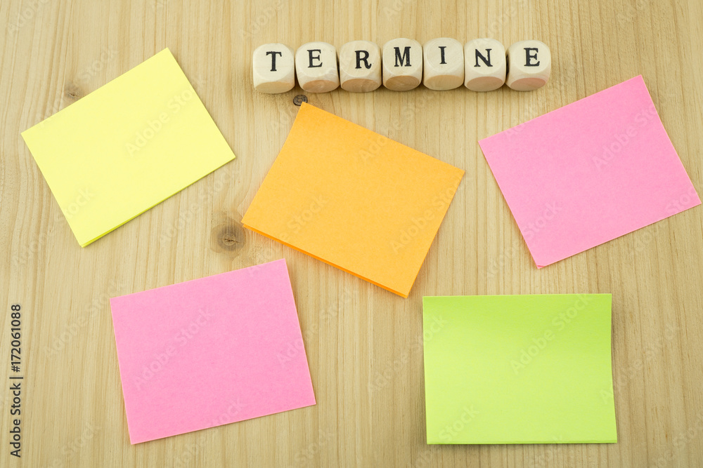 Viele bunte Zettel mit Textfreiraum, Holzbuchstaben mit den Worten wichtiger Termin, Holzhintergrund Viele bunte Zettel mit Textfreiraum, Holzbuchstaben mit den Worten wichtiger Termin, Holzhintergrund