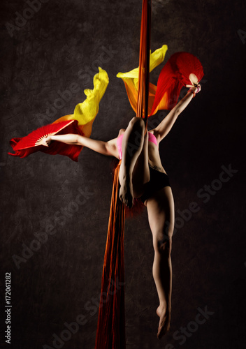 Beautiful sexy dancer on aerial silk, graceful contortion, acrobat performs a trick on a ribbons