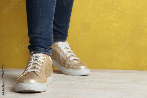 Female feet in golden sneakers