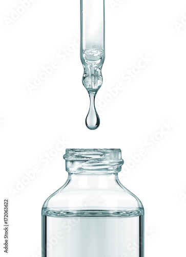 Tableau sur toile Drop falls from a pipette into a cosmetic bottle on white background