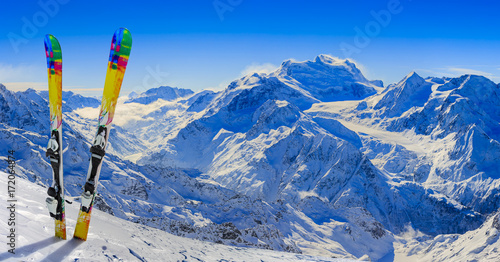 Skiing in winter season, mountains and ski equipments on the top of snowy mountains in sunny day. Swiss Alps. photo