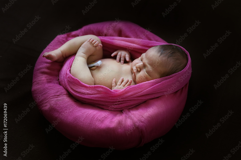 tender newborn baby wrapped in pink winding,dark tender newborn baby wrapped in pink winding,dark