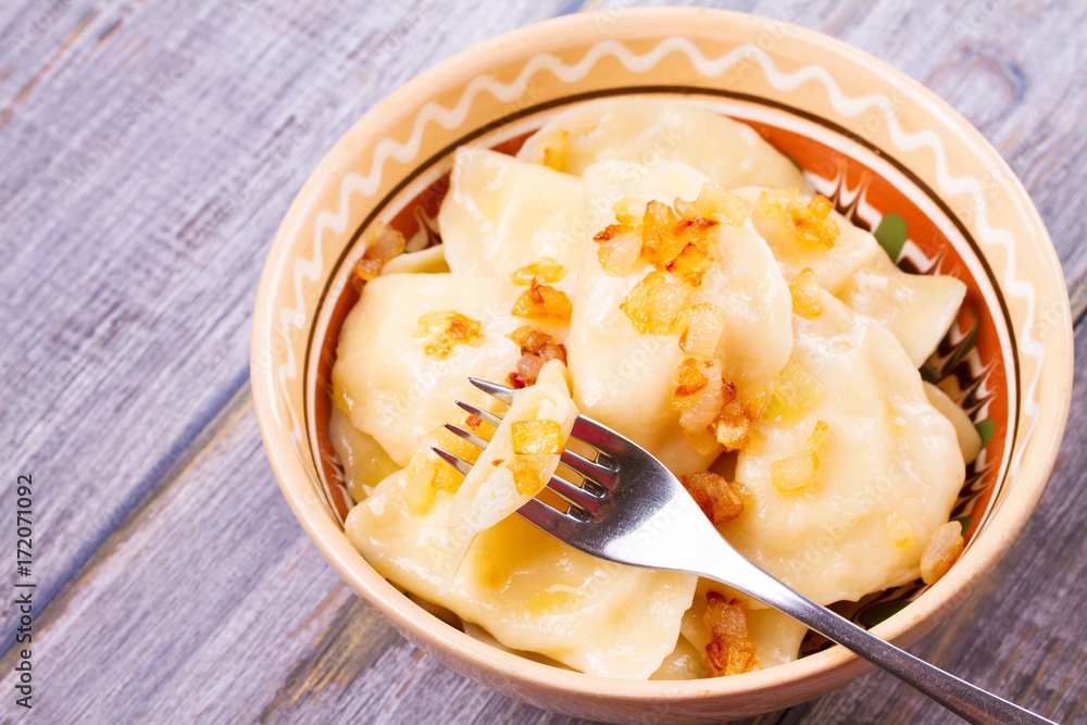 Dumplings, filled with potato and served with fried onion. Varenyky, vareniki, pierogi, pyrohy - popular dish in East Europe. Horizontal Dumplings, filled with potato and served with fried onion. Varenyky, vareniki, pierogi, pyrohy - popular dish in East Europe. Horizontal
