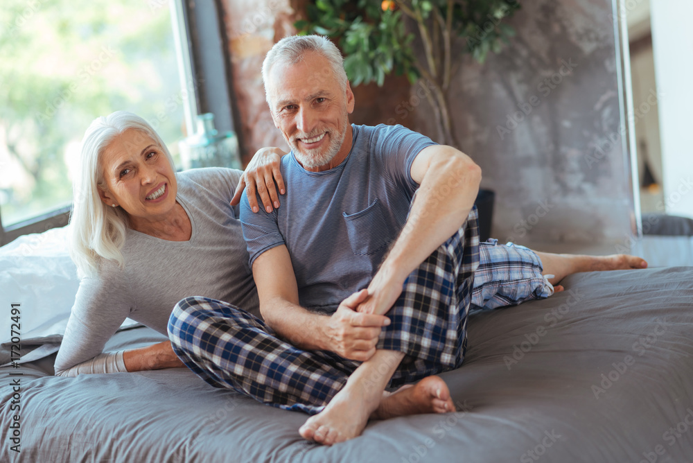 Positive lovign aged couple lying on the bed