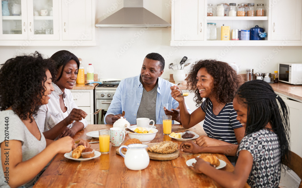 Family With Teenage Children Eating Breakfast In Kitchen Family With Teenage Children Eating Breakfast In Kitchen