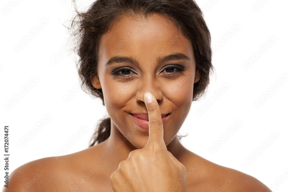Young dark skinned woman touching her nose Young dark skinned woman touching her nose