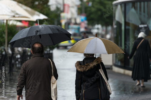 Personen mit Regenschirm