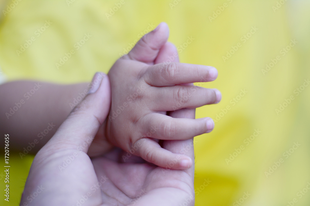 an adult woman holding a baby hand an adult woman holding a baby hand
