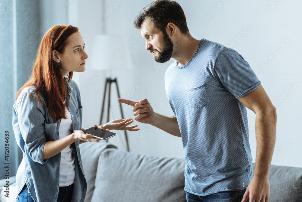 Fototapeta premium Angry upset man pointing at his wife