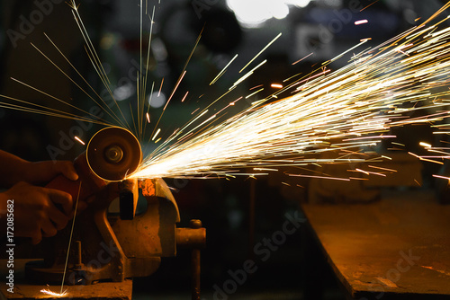 Man sawing metal by grinder