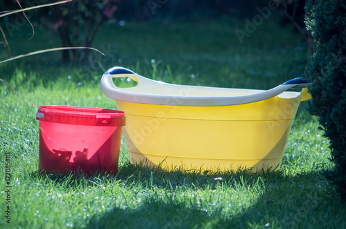 Red Bucket and Yellow Bowl on Grass in Piechowice, Poland