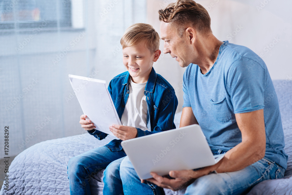 Little boy looking through printouts with his father Little boy looking through printouts with his father