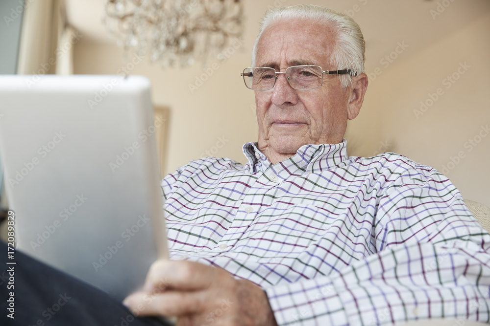 Senior man using a tablet computer at home, close up Senior man using a tablet computer at home, close up