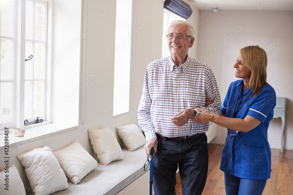 Fototapeta premium Nurse helping senior man walk using a walking stick