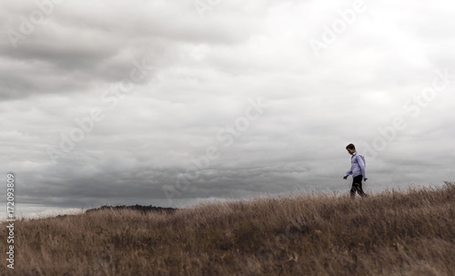 man who feels free in a field on a hill © Yalana