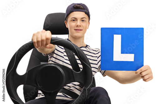 Teenage boy driving and showing an L-sign photo