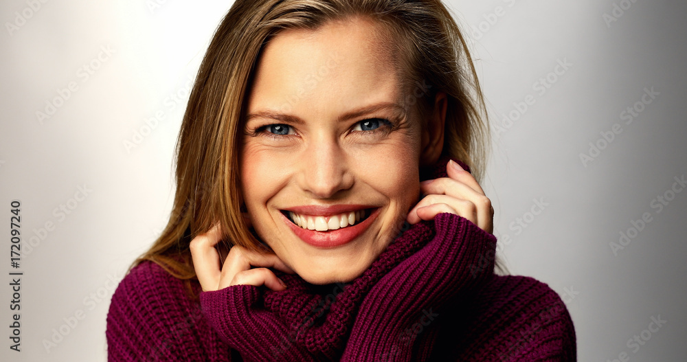 Blue eyed babe in cozy sweater, smiling in studio Blue eyed babe in cozy sweater, smiling in studio
