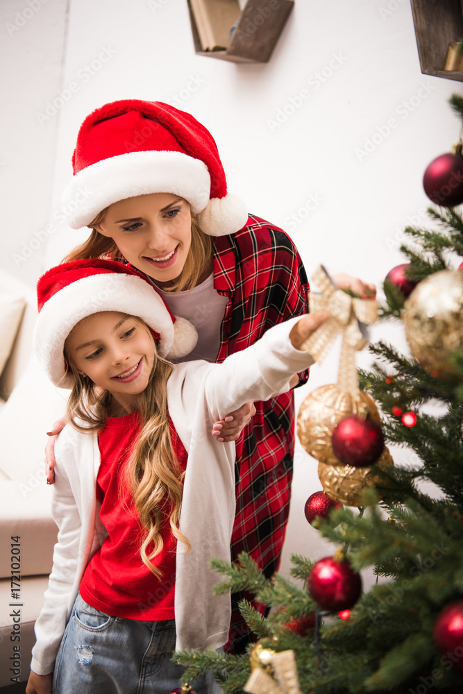 mother and daughter decorating christmas tree mother and daughter decorating christmas tree