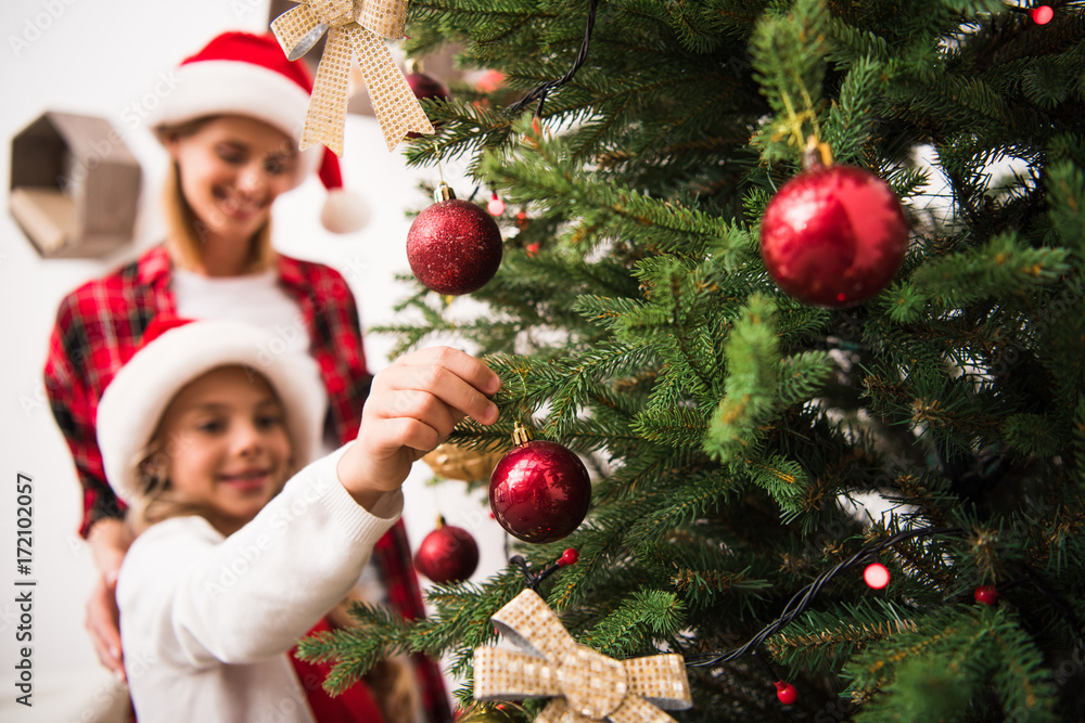 mother and daughter decorating christmas tree mother and daughter decorating christmas tree