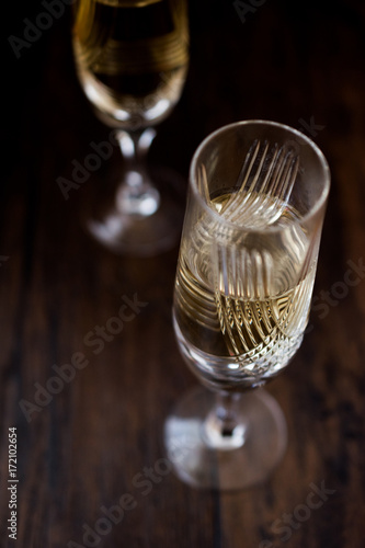 Champagne glasses on dark wooden surface.