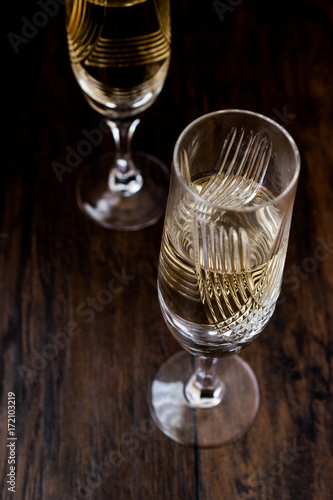 Champagne glasses on dark wooden surface.