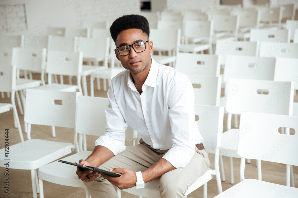 Fototapeta premium Young thinking african man sitting coworking