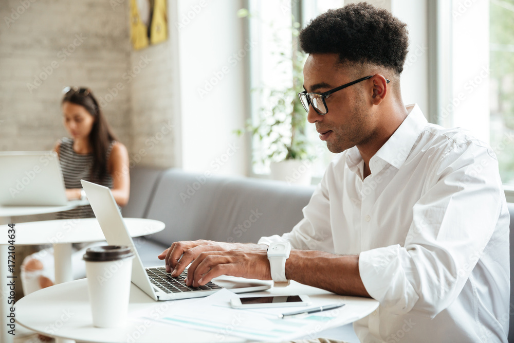 Concentrated young african man sitting coworking Concentrated young african man sitting coworking