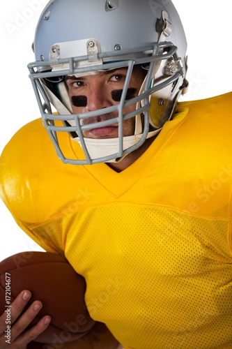 Portrait of determined football player wearing helmet holding