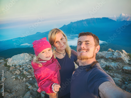 Family hikers making selfie on a top of mountain photo