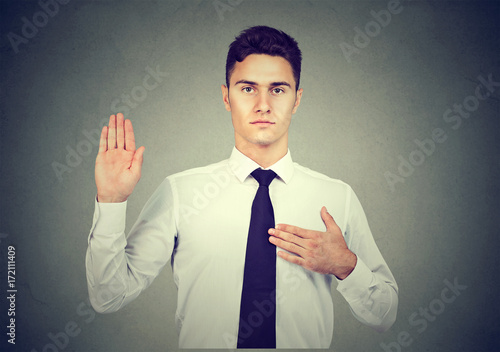 Canvastavla Handsome young business man making an oath promise on gray background