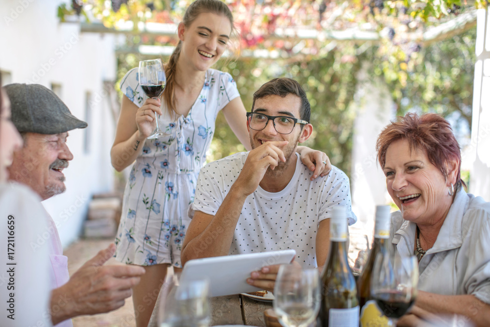 Family having lunch outdoors under grapevine trellis Family having lunch outdoors under grapevine trellis