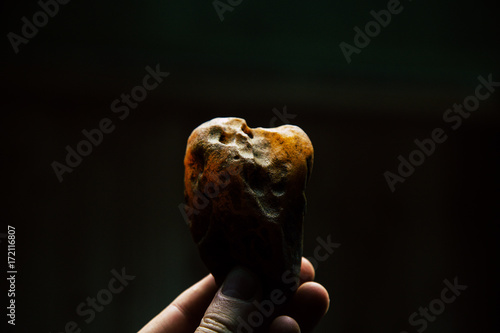 Amber in the hand. On a dark background. Close-up amber. Amber for advertising and sales. Colored stone.