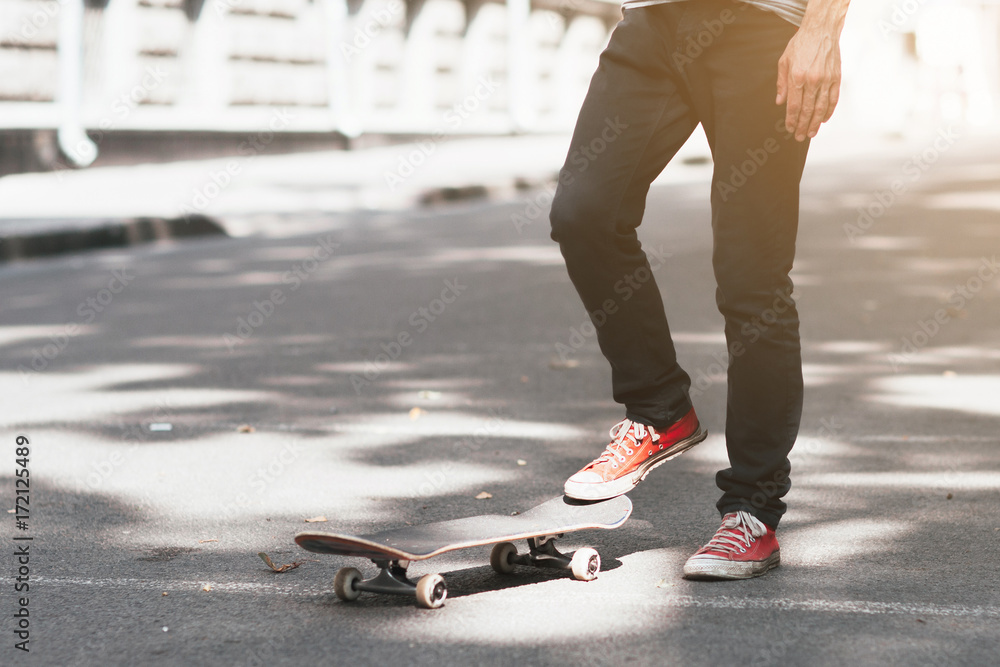 Unrecognizable hipster man with skateboard. First step in skateboarding sport challenge, ready to adventure. Modern urban lifestyle and culture of youth background with free space Unrecognizable hipster man with skateboard. First step in skateboarding sport challenge, ready to adventure. Modern urban lifestyle and culture of youth background with free space