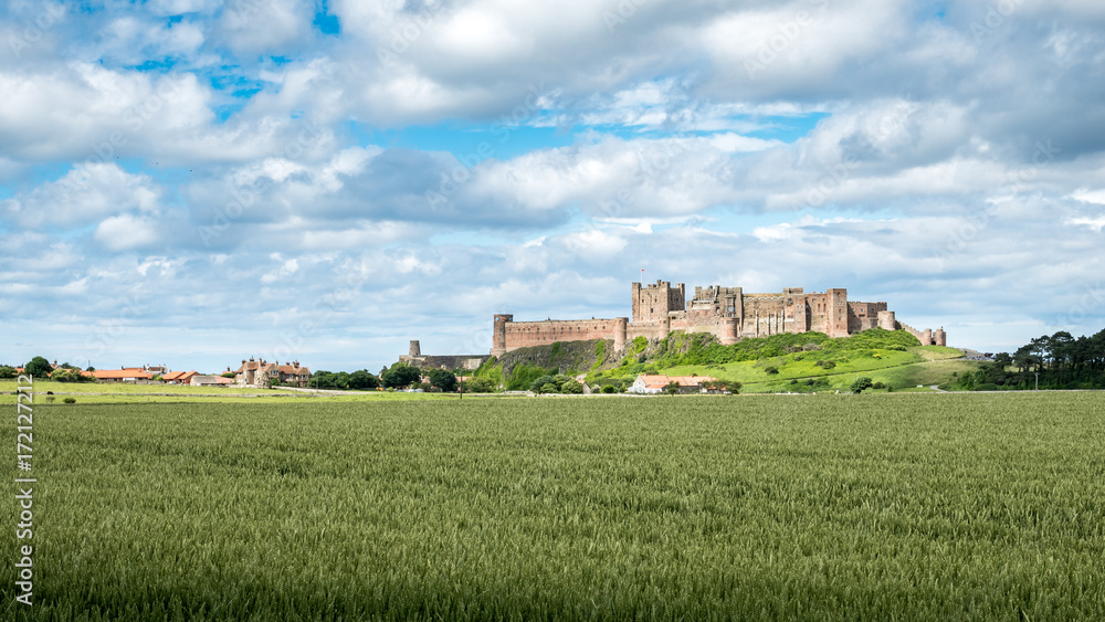 Bamburgh Castle, England. A view over the Northumberland countryside in the north east of England towards the landmark castle at Bamburgh