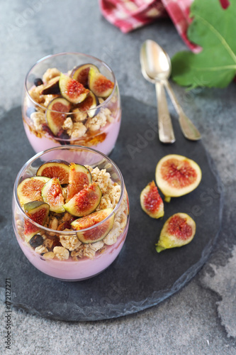 Two glasses of fruit yogurt with granola, figs and honey for light breakfast