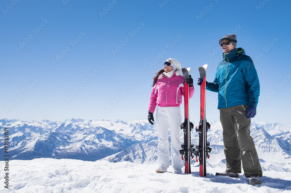 Couple holding ski - obrazy, fototapety, plakaty 