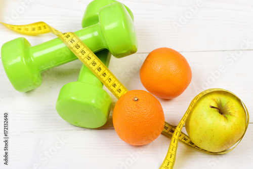 training concept, dumbbells weight with measuring tape ,fruit