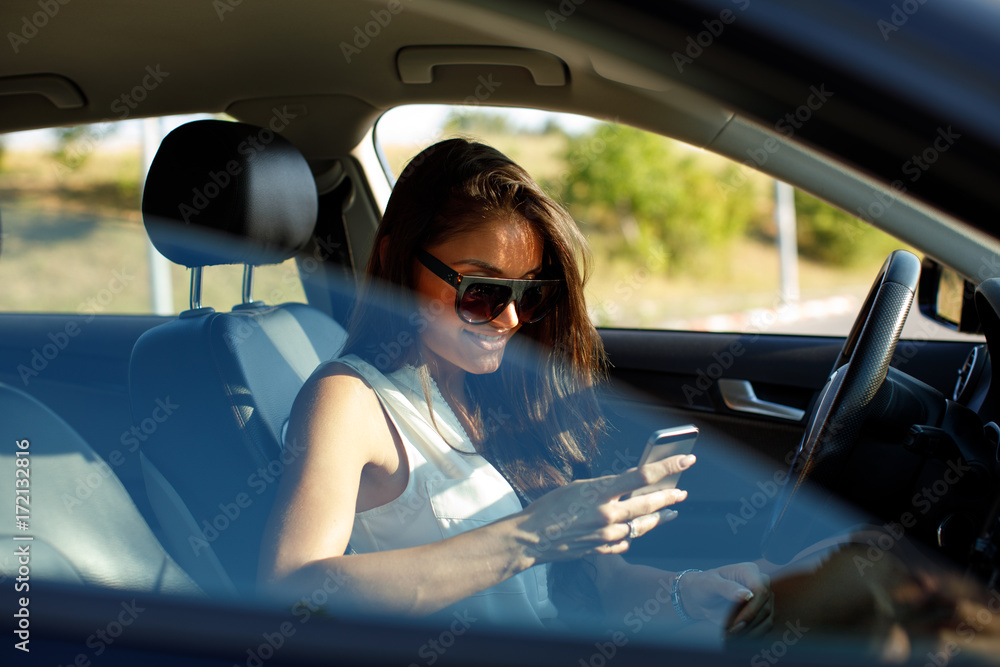 Attractive woman texting in a car on the road Attractive woman texting in a car on the road