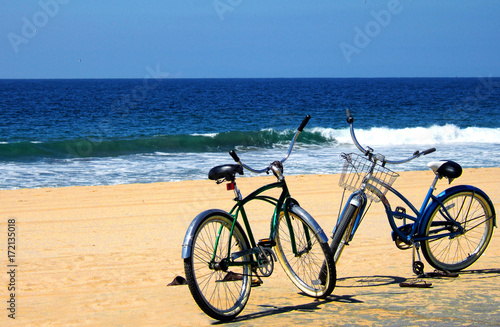Bicycles on the beach near the ocean © Robin Keefe