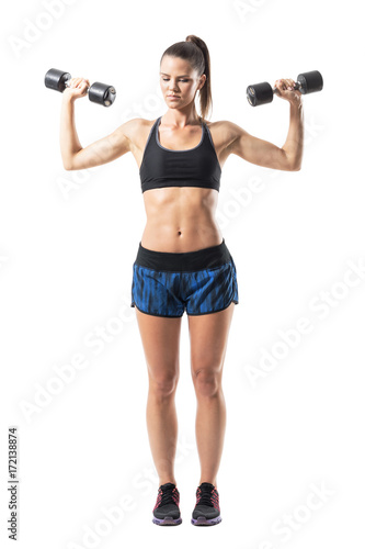 Tough fitness female model weightlifting shoulder exercise lower arms position. Full body length portrait isolated on white studio background. 